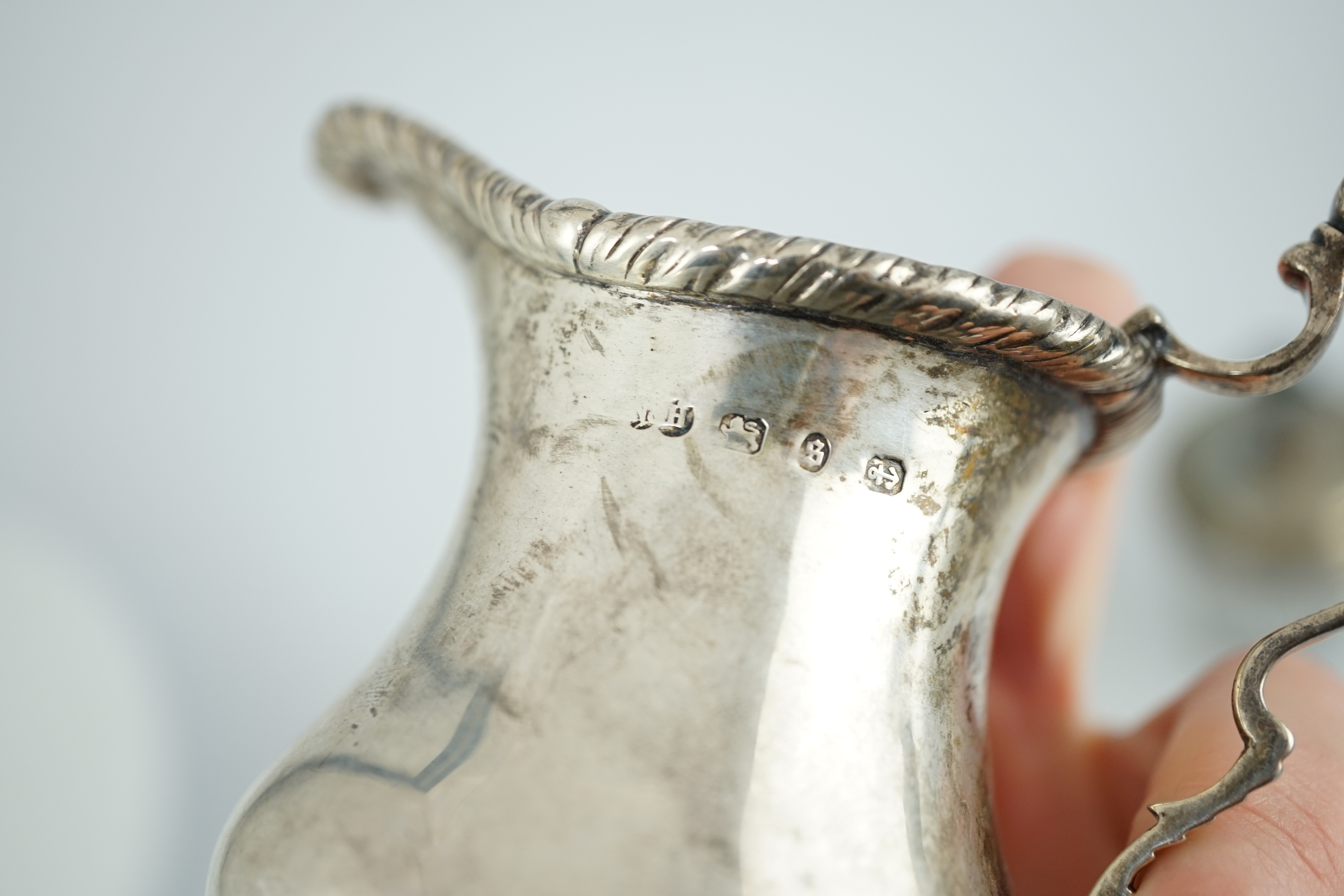 Two George III silver mounted glass cruet bottles, London, 1808, height 12.6cm and a late Victorian silver inverted pear shaped cream jug.